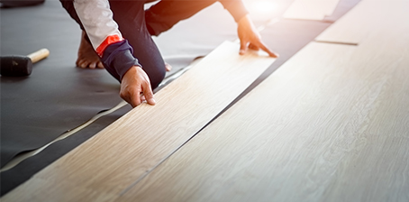 Installer installing vinyl plank flooring  